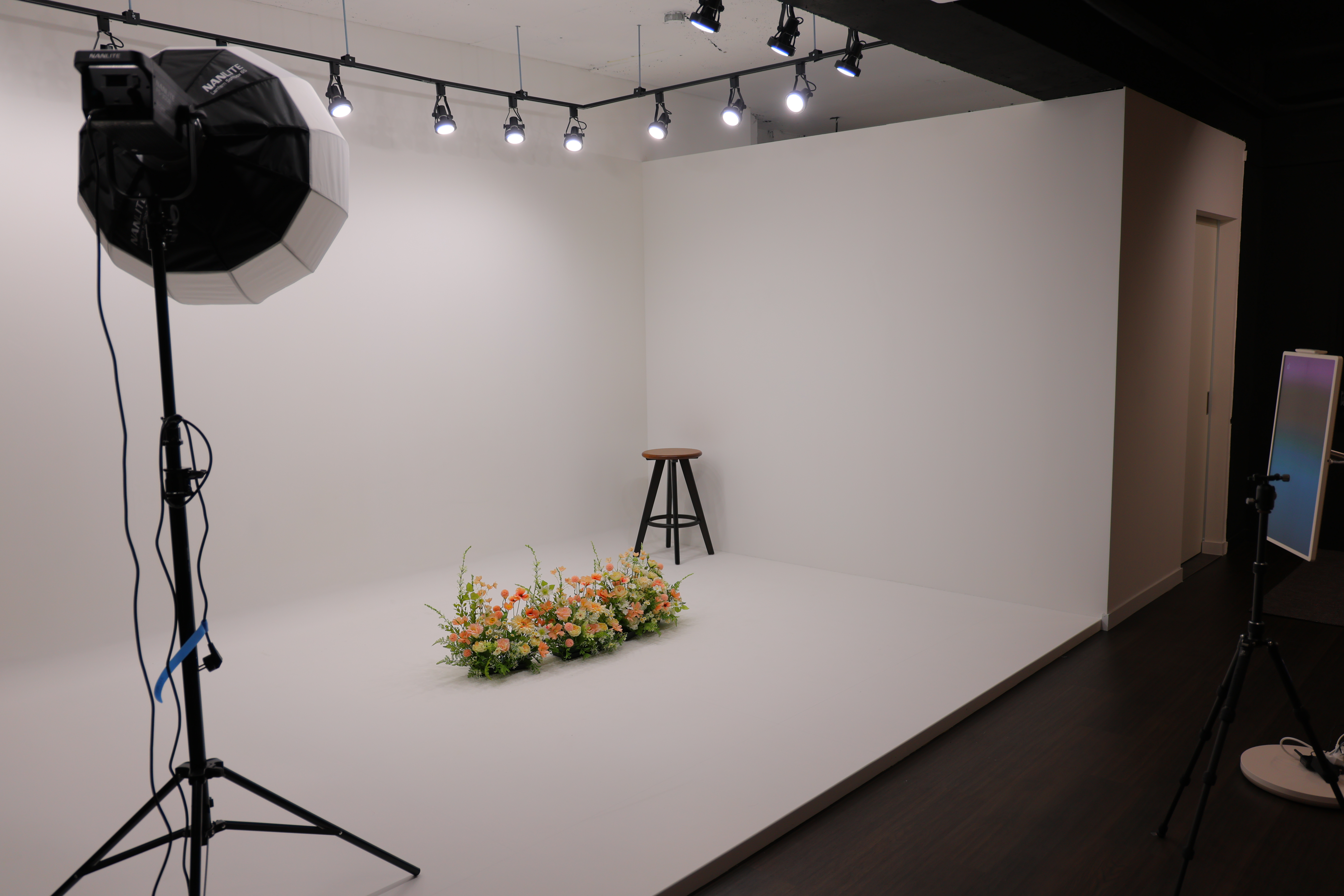 조명 장비와 꽃 장식이 세팅된 전문 화보 촬영 스튜디오 전경